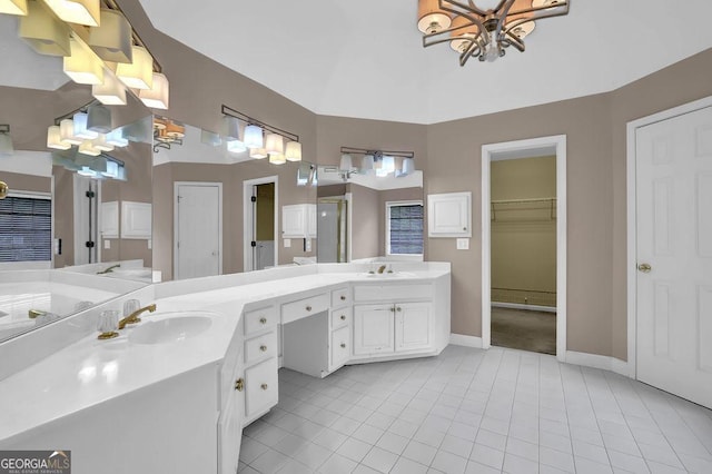 full bathroom with tile patterned floors, double vanity, a stall shower, baseboards, and a chandelier