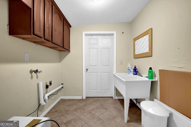 laundry room with electric dryer hookup, hookup for a washing machine, light tile patterned floors, and cabinet space