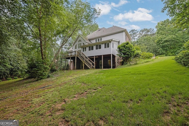rear view of house with stairs, a deck, and a lawn