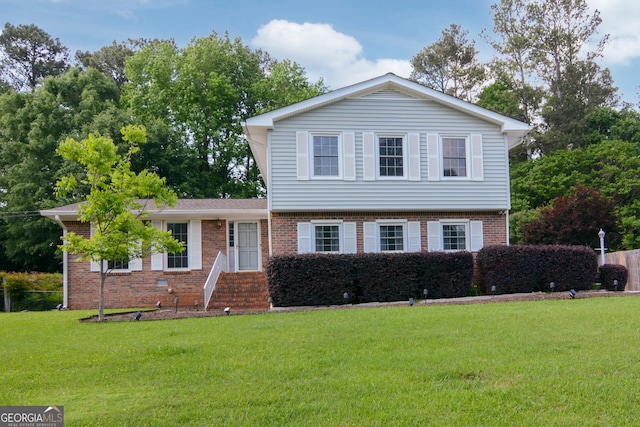 tri-level home with entry steps, a front lawn, and brick siding