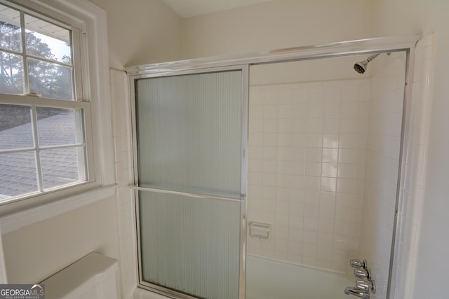 full bath featuring bath / shower combo with glass door