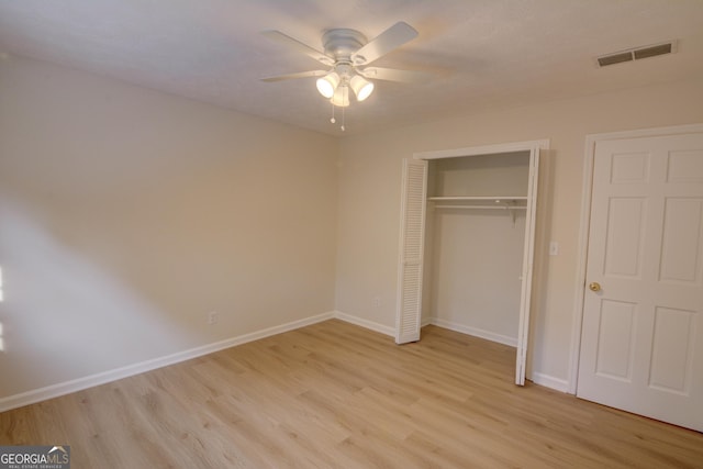 unfurnished bedroom featuring baseboards, a closet, light wood-style flooring, and visible vents