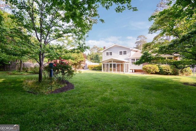 view of yard with a sunroom and fence