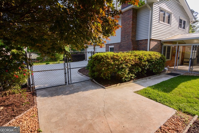 exterior space with fence, a gate, and brick siding