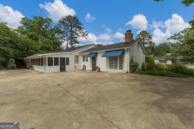 603 Piney Woods Dr, Lagrange, GA 30240 - back of house featuring brick siding, driveway, a chimney, and a sunroom