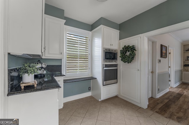 603 Piney Woods Dr, Lagrange, GA 30240 - kitchen with appliances with stainless steel finishes, baseboards, white cabinets, dark stone counters, and light tile patterned flooring