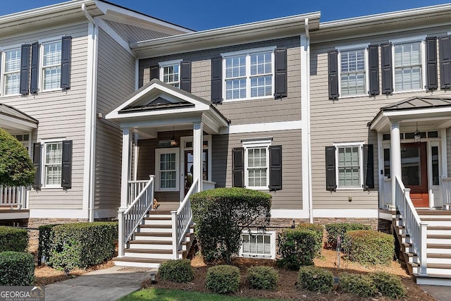 townhome / multi-family property featuring a porch and stairway