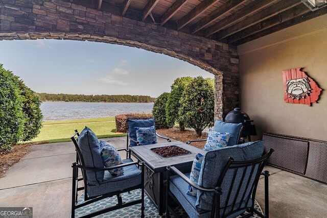 view of patio with a water view and an outdoor fire pit