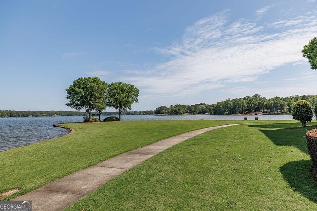 surrounding community featuring a lawn and a water view