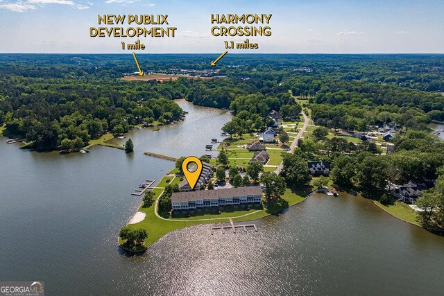 drone / aerial view with a water view and a wooded view