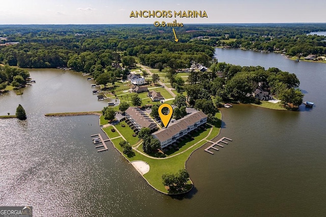 bird's eye view with a water view and a wooded view