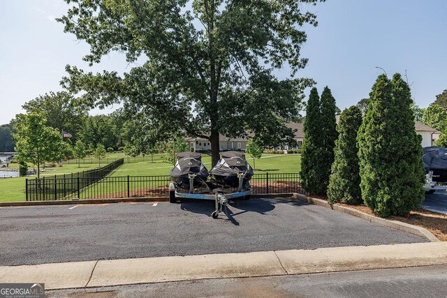 view of property's community with a lawn and fence