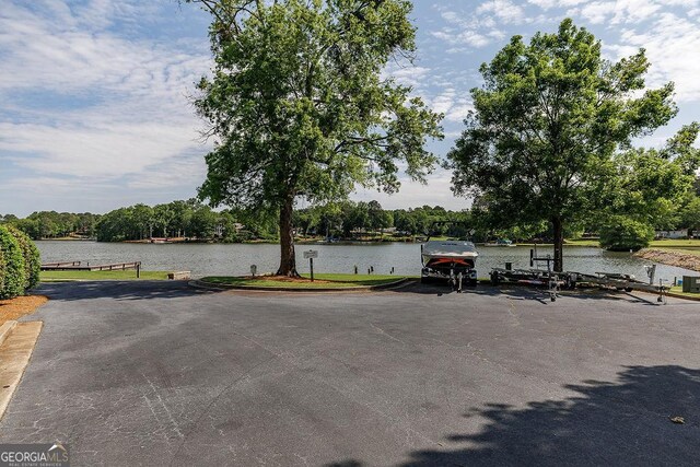 view of parking with a boat dock and a water view
