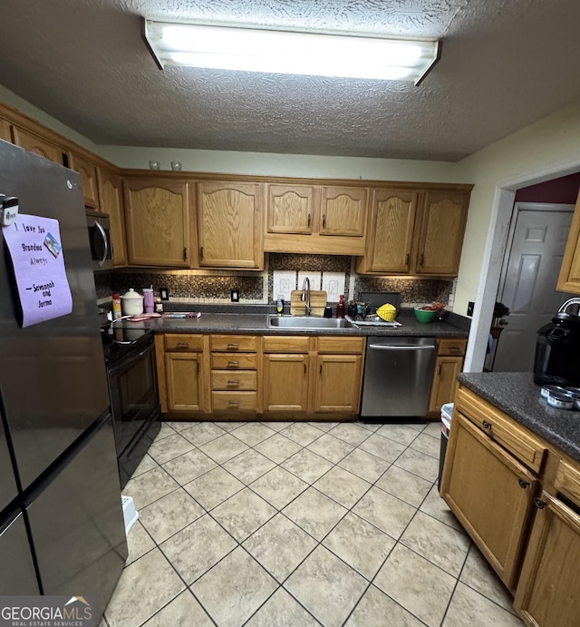 182 Boxer Ln, Rock Spring, GA 30739 - kitchen featuring appliances with stainless steel finishes, dark countertops, decorative backsplash, brown cabinets, and light tile patterned floors