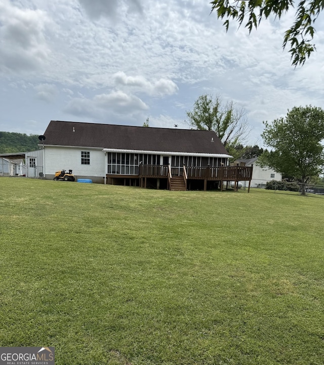 rear view of property with a yard and a deck