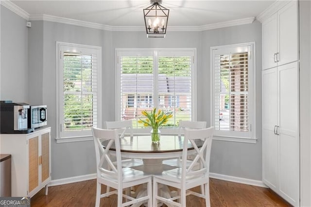dining space with baseboards, ornamental molding, and wood finished floors