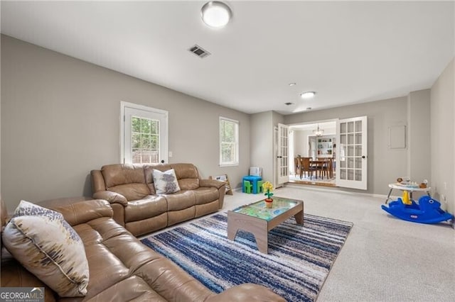 carpeted living area featuring baseboards and visible vents