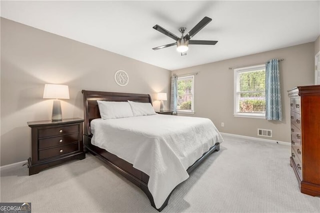 bedroom featuring light colored carpet, baseboards, visible vents, and a ceiling fan