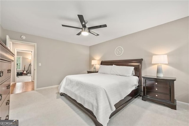 bedroom featuring baseboards, a ceiling fan, and light carpet