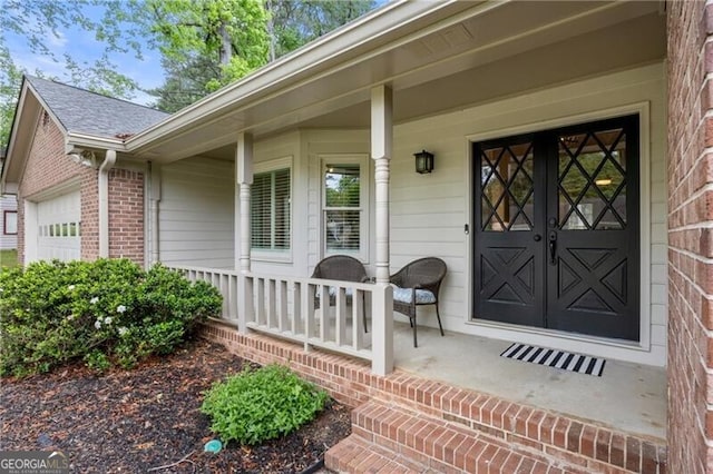 entrance to property with an attached garage, roof with shingles, covered porch, and brick siding