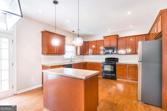kitchen featuring backsplash, black appliances, light wood-type flooring, and brown cabinetry