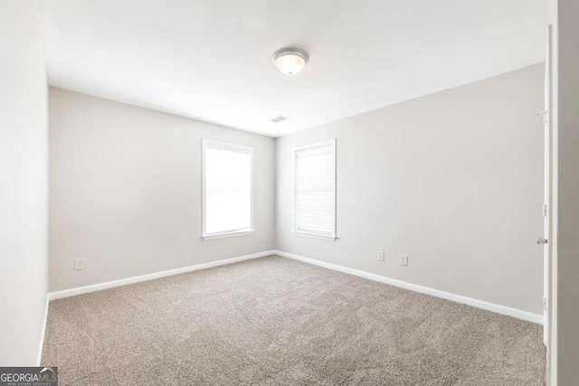 carpeted empty room featuring baseboards