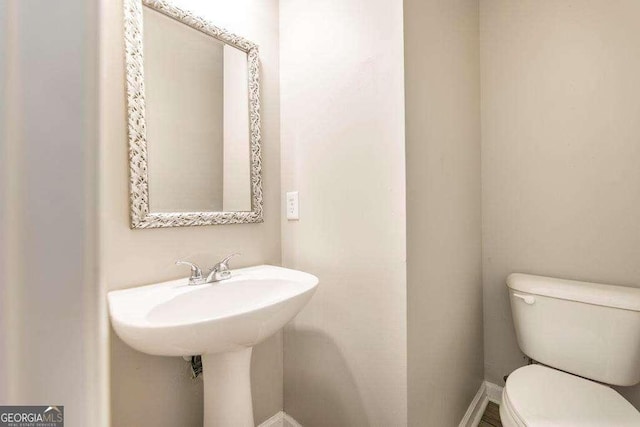 bathroom with baseboards and toilet