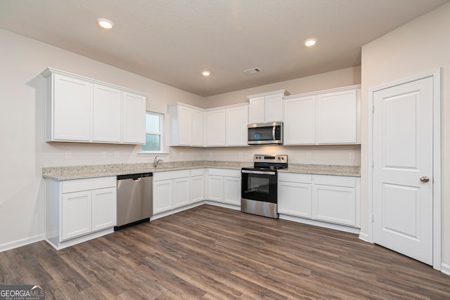 264 Oliver Dr, Locust Grove, GA 30248 - kitchen featuring dark wood-style flooring, light stone countertops, white cabinets, a sink, and stainless steel appliances