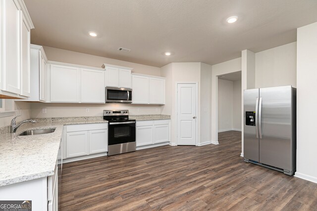 264 Oliver Dr, Locust Grove, GA 30248 - kitchen featuring a sink, stainless steel appliances, baseboards, white cabinetry, and dark wood-type flooring
