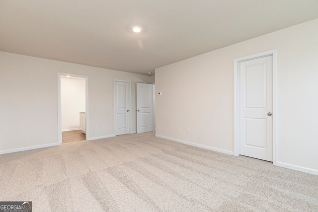 264 Oliver Dr, Locust Grove, GA 30248 - unfurnished bedroom featuring baseboards, carpet flooring, and ensuite bath