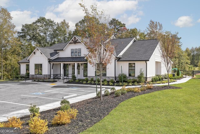 264 Oliver Dr, Locust Grove, GA 30248 - view of front of house with a porch, board and batten siding, a standing seam roof, a front yard, and uncovered parking