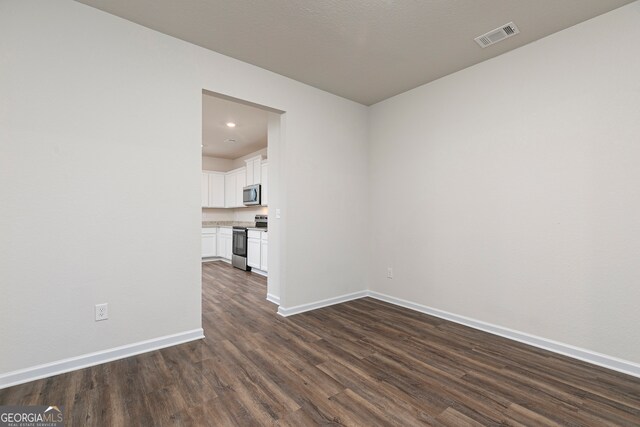 264 Oliver Dr, Locust Grove, GA 30248 - unfurnished living room with dark wood-style flooring, baseboards, visible vents, and recessed lighting