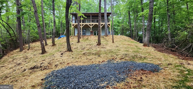 exterior space with a forest view and a wooden deck