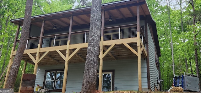 view of property exterior featuring a ceiling fan and a deck