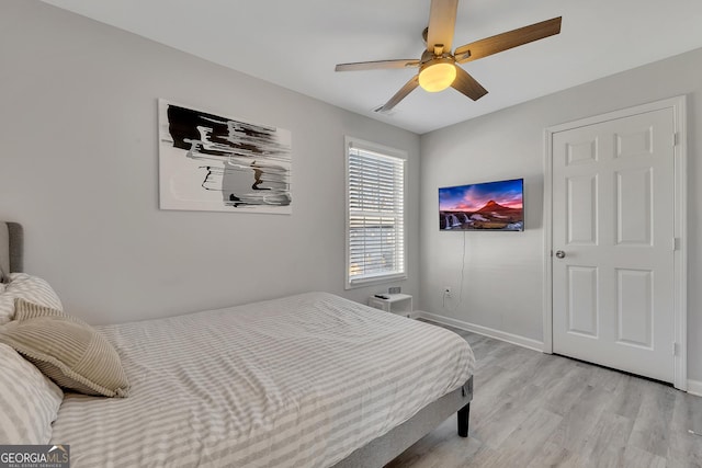 bedroom featuring baseboards, a ceiling fan, and light wood-type flooring