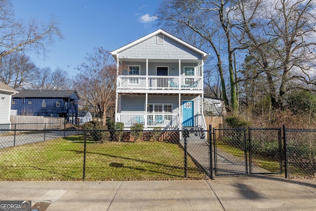traditional home with covered porch, a front yard, a gate, concrete driveway, and a fenced front yard