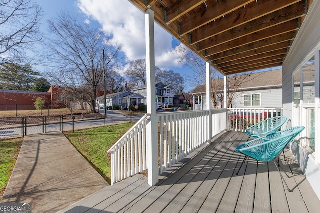 deck featuring a porch, fence, and a residential view
