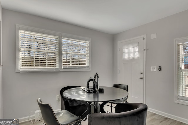 dining space featuring baseboards and light wood-style flooring