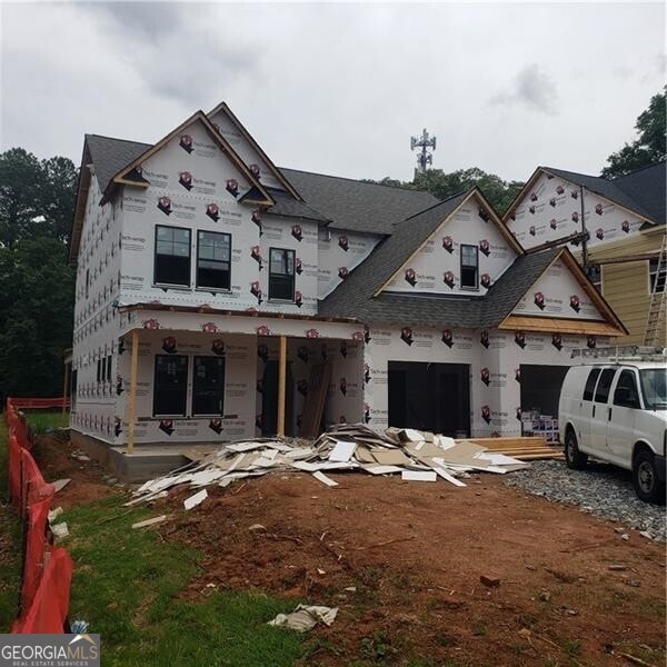 unfinished property with a porch, a shingled roof, and an attached garage