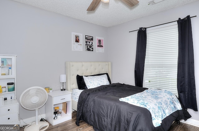 bedroom featuring baseboards, a textured ceiling, ceiling fan, and wood finished floors