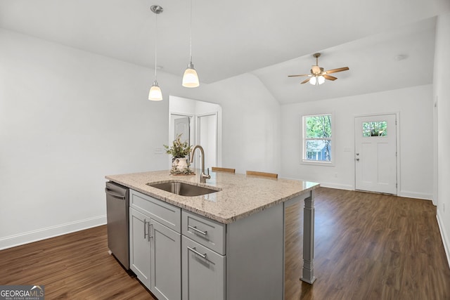 kitchen featuring ceiling fan, stainless steel dishwasher, a sink, baseboards, and lofted ceiling