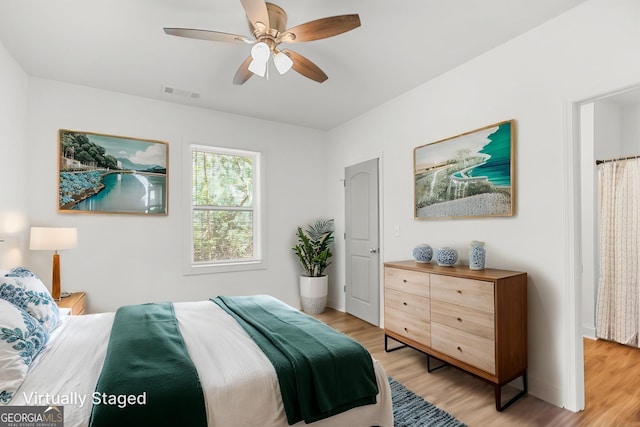 bedroom with a ceiling fan, light wood-type flooring, and visible vents