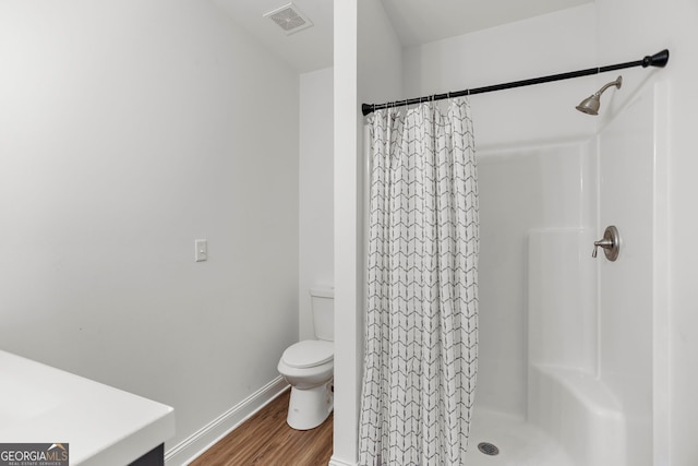 bathroom with toilet, baseboards, curtained shower, wood finished floors, and visible vents