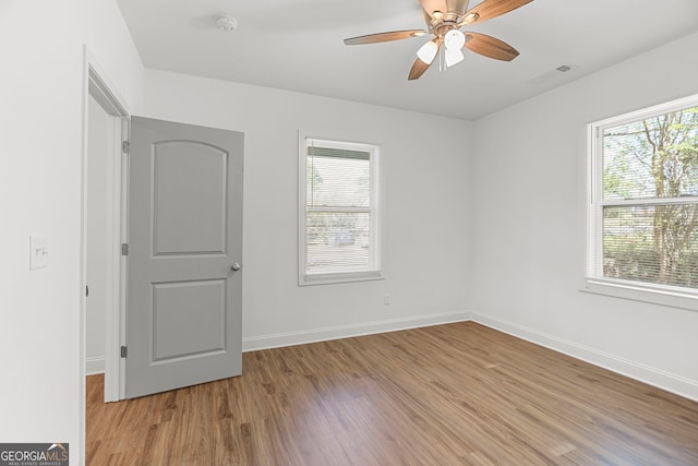 unfurnished room featuring light wood-type flooring, baseboards, and ceiling fan