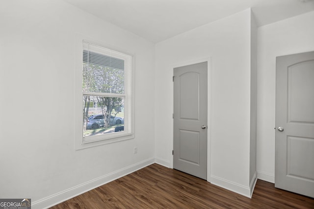 interior space featuring baseboards and dark wood-style floors