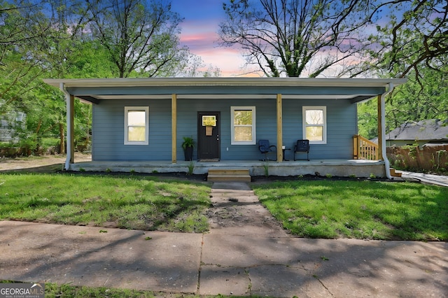 view of front of property featuring covered porch and a lawn