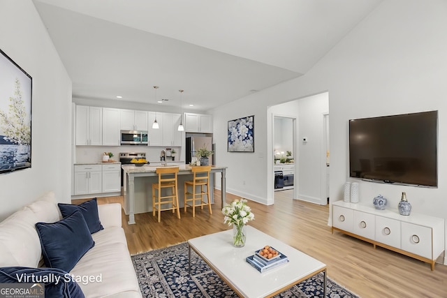 living area featuring light wood-type flooring, recessed lighting, and baseboards