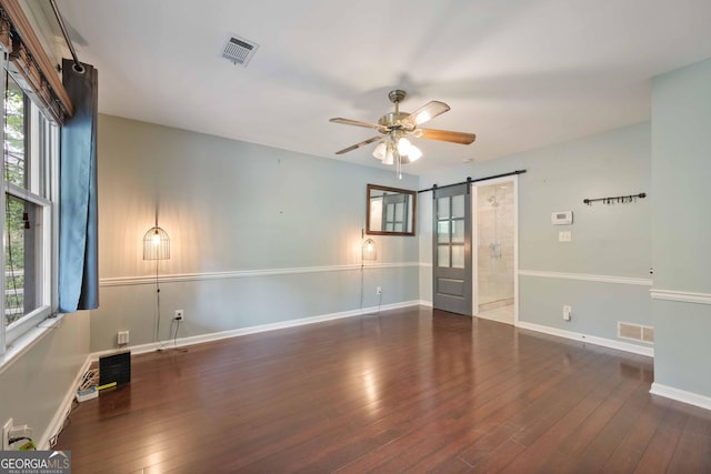 1007 Natalie Ln SE, Smyrna, GA 30082 - spare room featuring wood-type flooring, visible vents, a barn door, and plenty of natural light