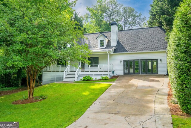 1007 Natalie Ln SE, Smyrna, GA 30082 - new england style home featuring a front lawn, covered porch, french doors, a chimney, and driveway