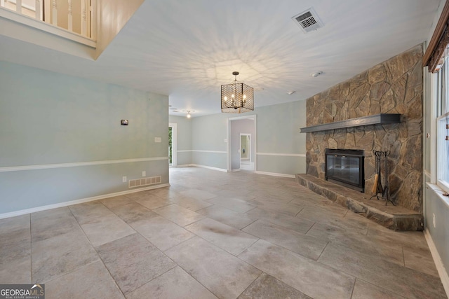 1007 Natalie Ln SE, Smyrna, GA 30082 - unfurnished living room featuring baseboards, a notable chandelier, a stone fireplace, and visible vents